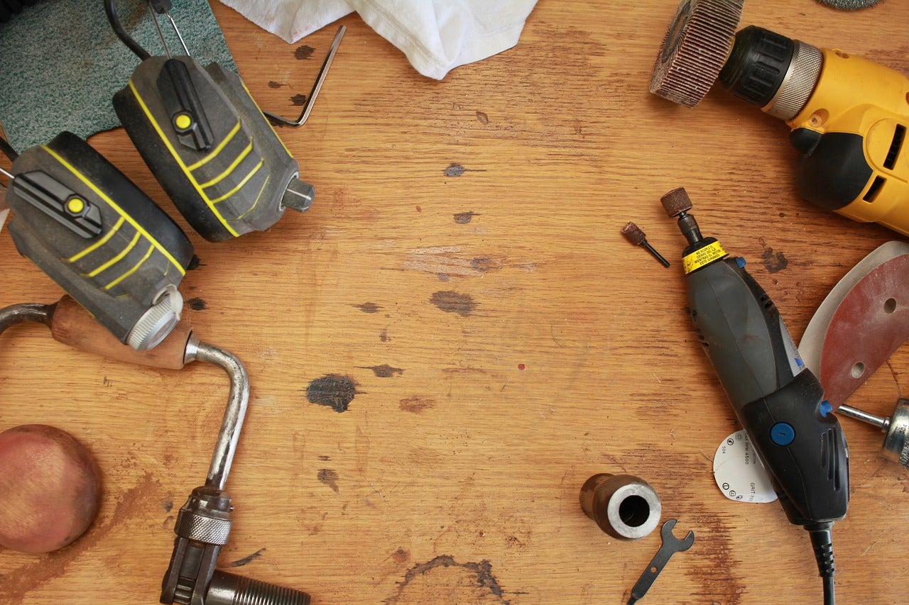 A workbench with several power tools, drills, and grinders.