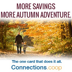 MORE SAVINGS, MORE AUTUMN ADVENTURES. The one card that does it all. Connections.coop - A father and his young son walking down a lane through a forest of autumn-colored trees.