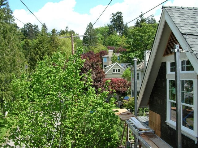 Scaffolding along the gable of a house near overhead power lines